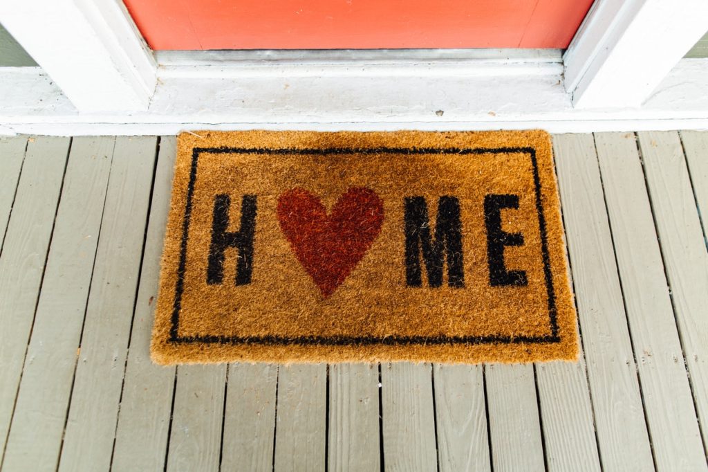 Mat with the word home written on it at a front door