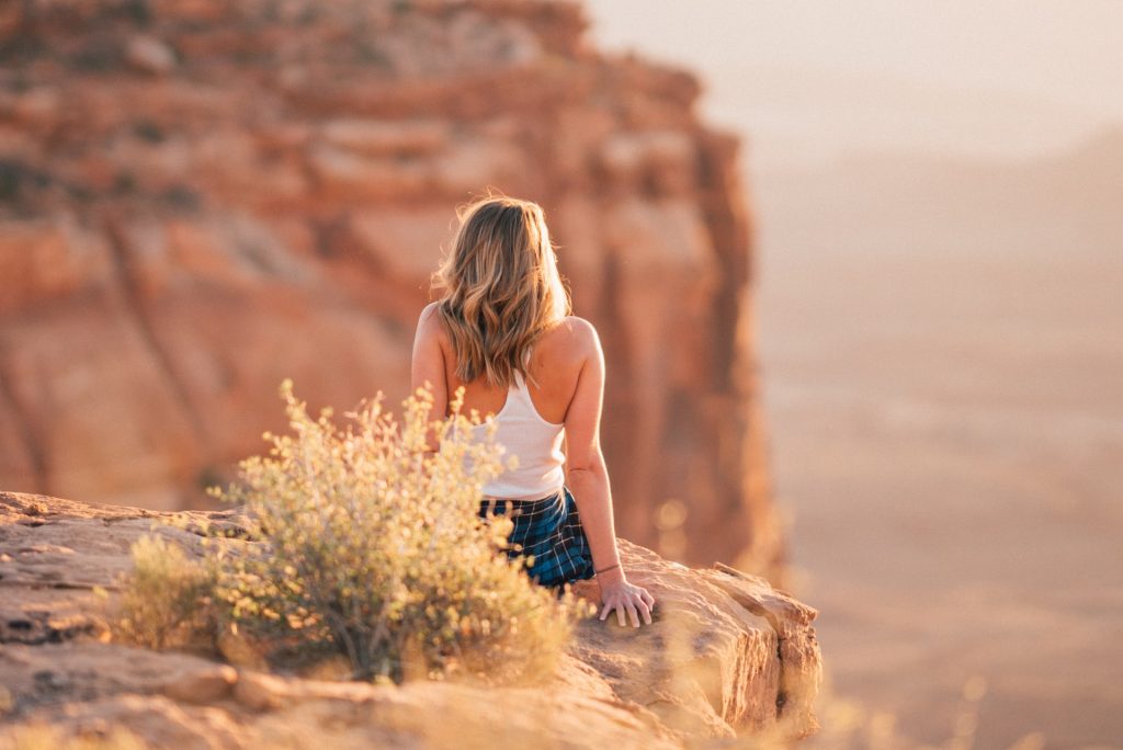 Girl sitting on mountain top