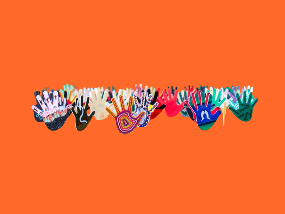 photo of coloured cardboard hands with indigenous drawings on them